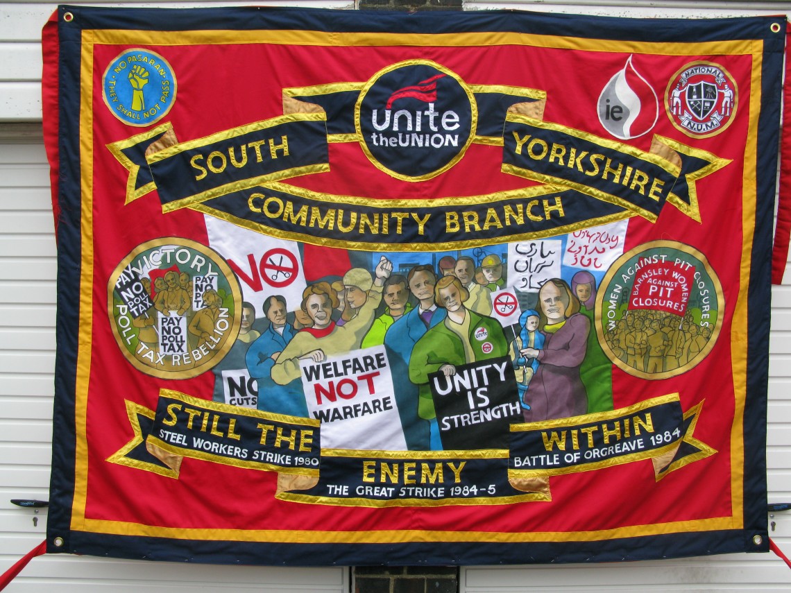 Ed Hall: a UNITE szakszervezet transzparense a társadalombiztosítási rendszer védelmében rendezett felvonuláson Manchesterben 2013. szeptember 29-én © V&A